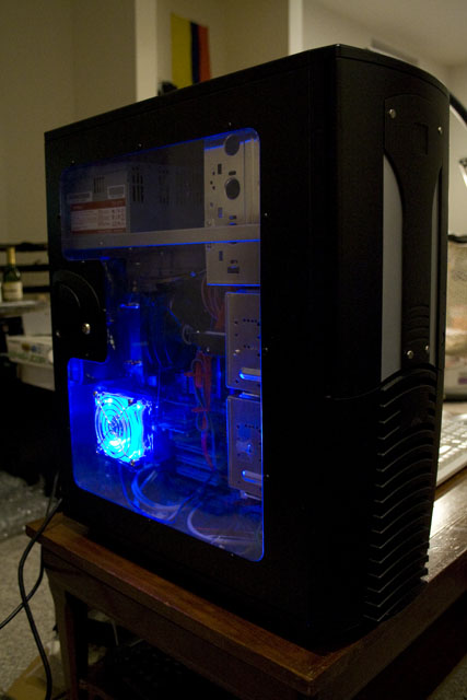 Left front view showing the clear acrylic side panel with blue LED fan