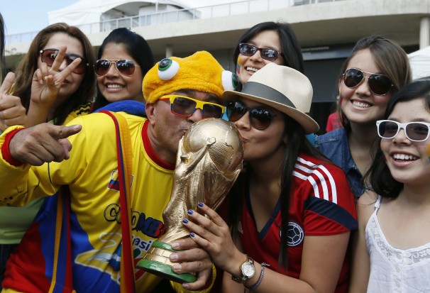 Colombian national soccer team fans kiss a mock World Cup trophy during their team's training session at Estadio Mineirao in Belo Horizonte, Brazil, 13 June 2014